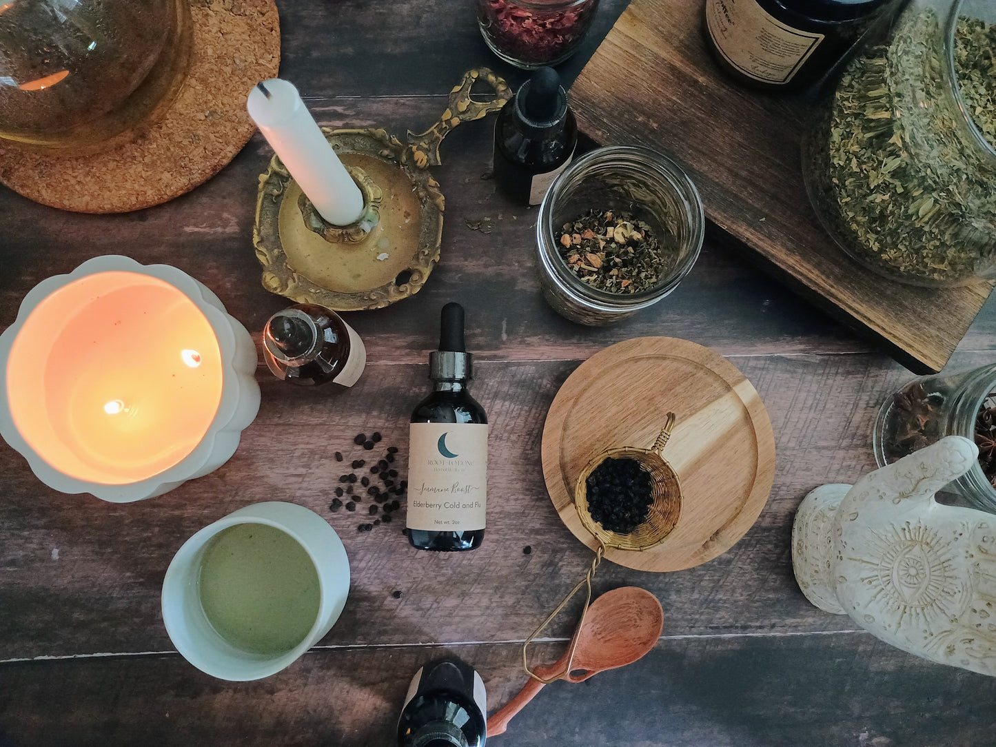 Herbal remedies and wellness items on a wooden surface with a lit candle.