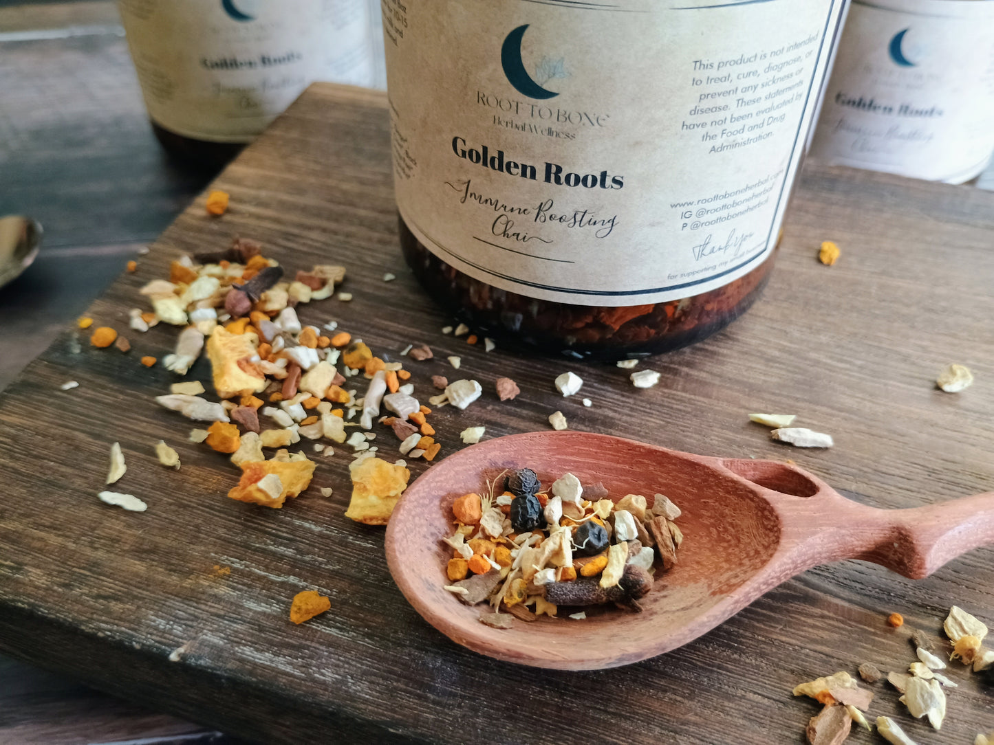 Tea packaging with a wooden spoon containing tea leaves on a wooden surface