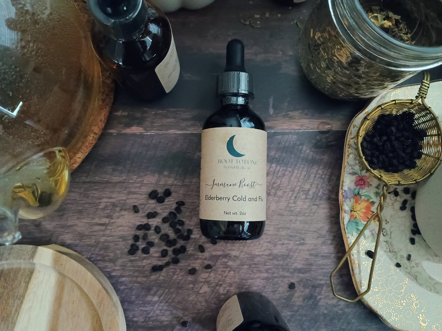 Bottle of elderberry tincture on a wooden surface with ingredients around
