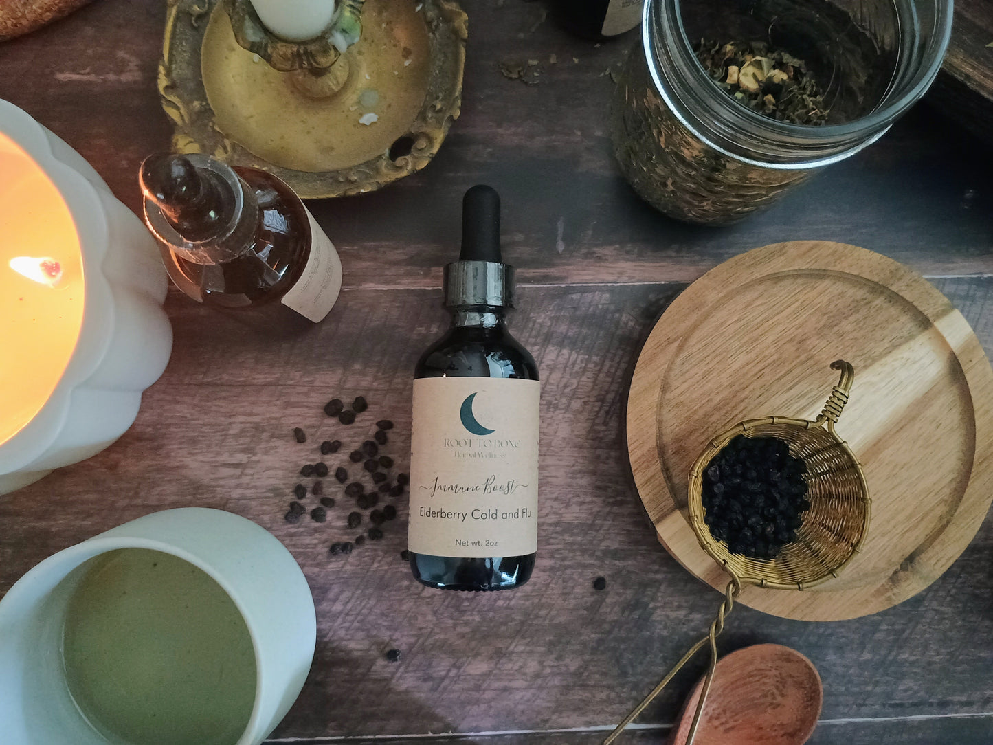 Bottle of tincture on a wooden surface with herbs and candles
