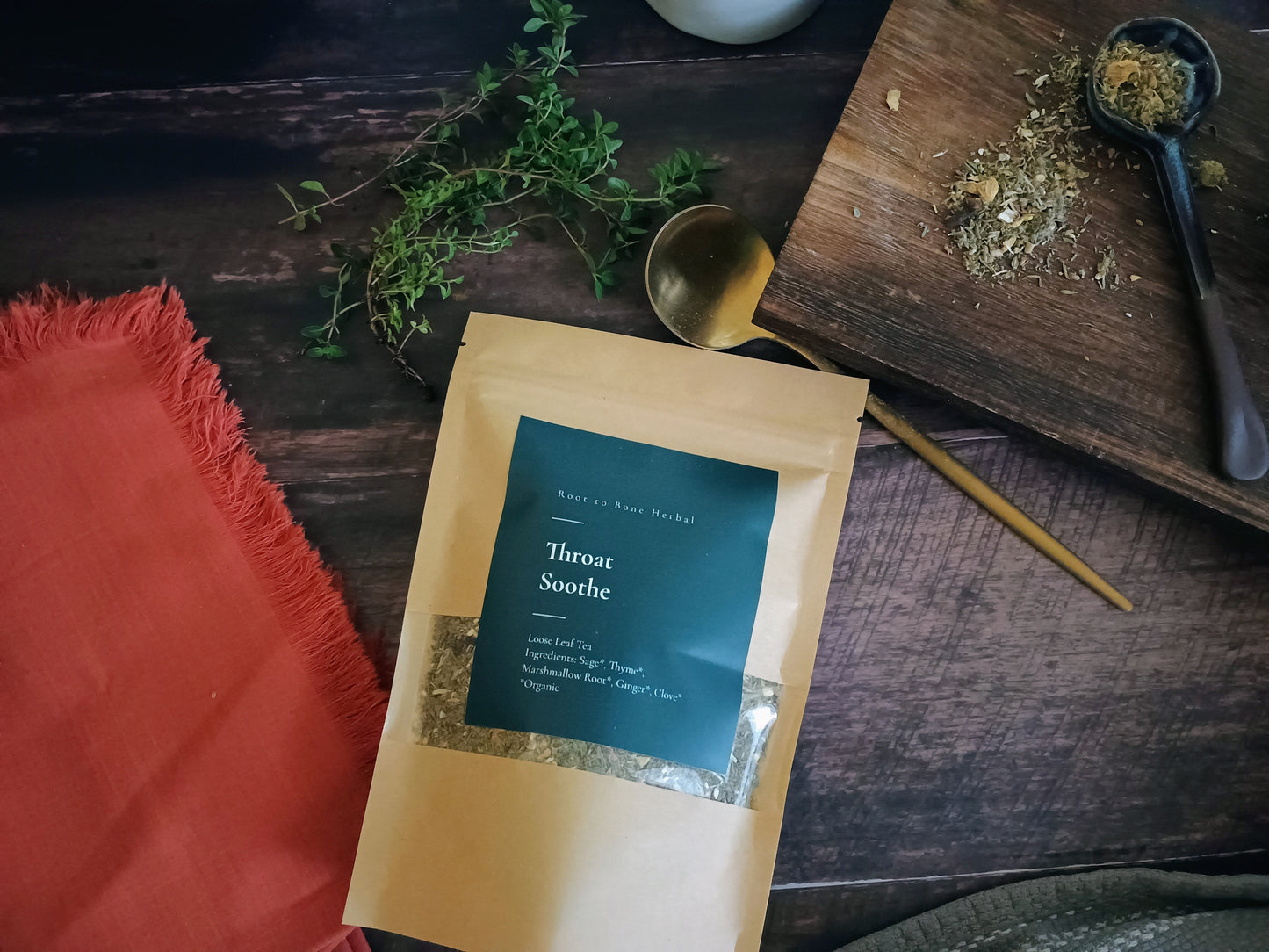 Package of 'Throat Soothe' on a wooden surface with herbs and a spoon.