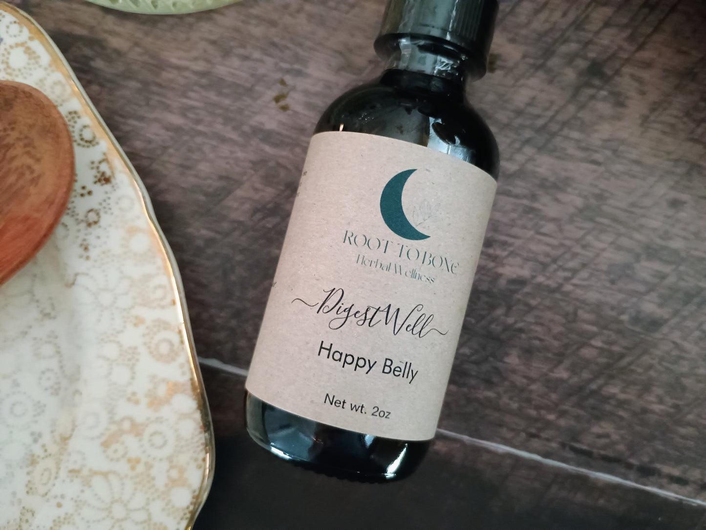 Bottle of 'Happy Belly' with a label on a wooden surface