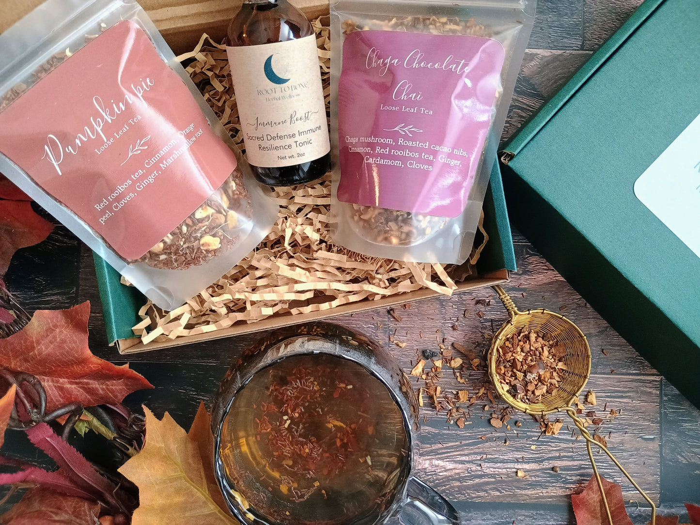Tea packaging with a teacup and tea leaves on a wooden surface