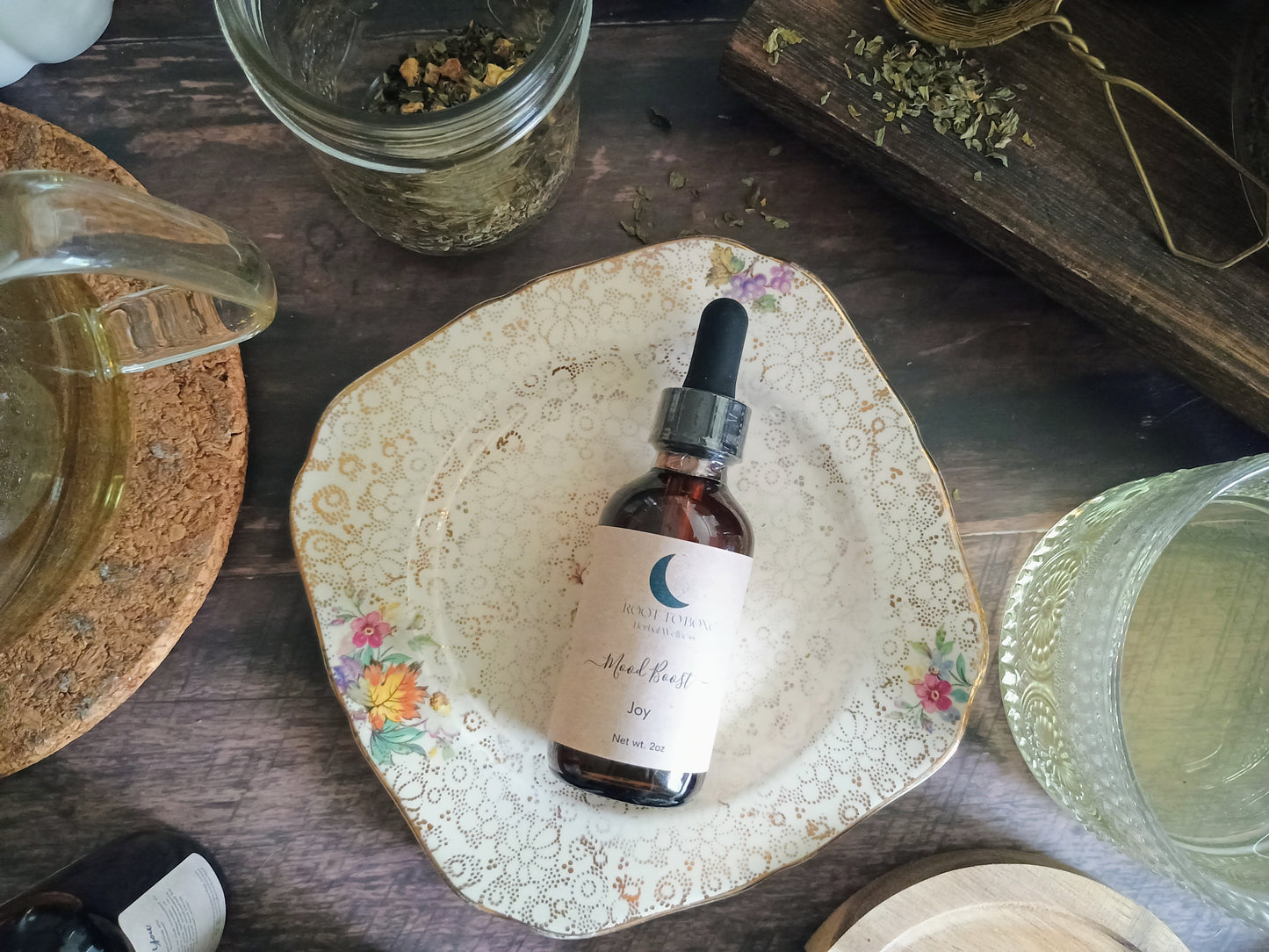 Bottle of tincture on a decorative plate with a wooden surface and jars in the background