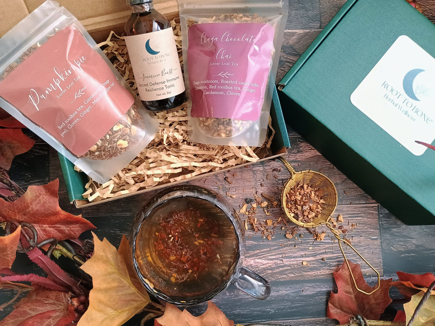 Tea packaging with a mug of tea on a wooden surface with autumn leaves.