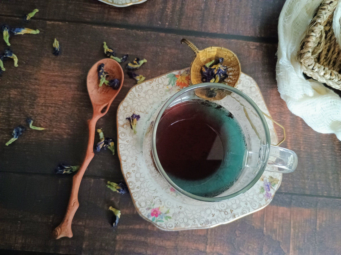 Butterfly pea tea, naturally blue tea with herbs and a wooden spoon