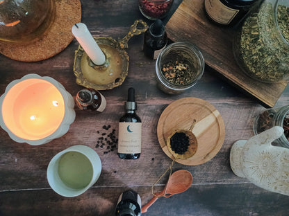 Herbal remedies and wellness items on a wooden surface with a lit candle.