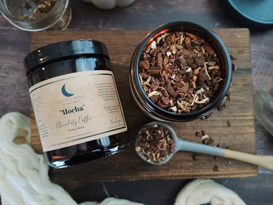 Jar of 'Mocha' coffee blend on a wooden board with a spoonful of  roots and herbs.