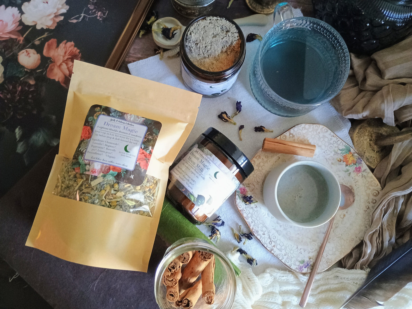 Herbal tea packaging, jars, and a cup on a table with a floral pattern.