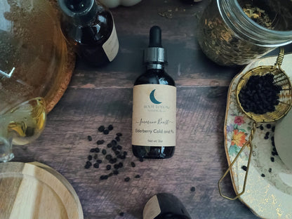 Bottle of elderberry tincture on a wooden surface with ingredients around