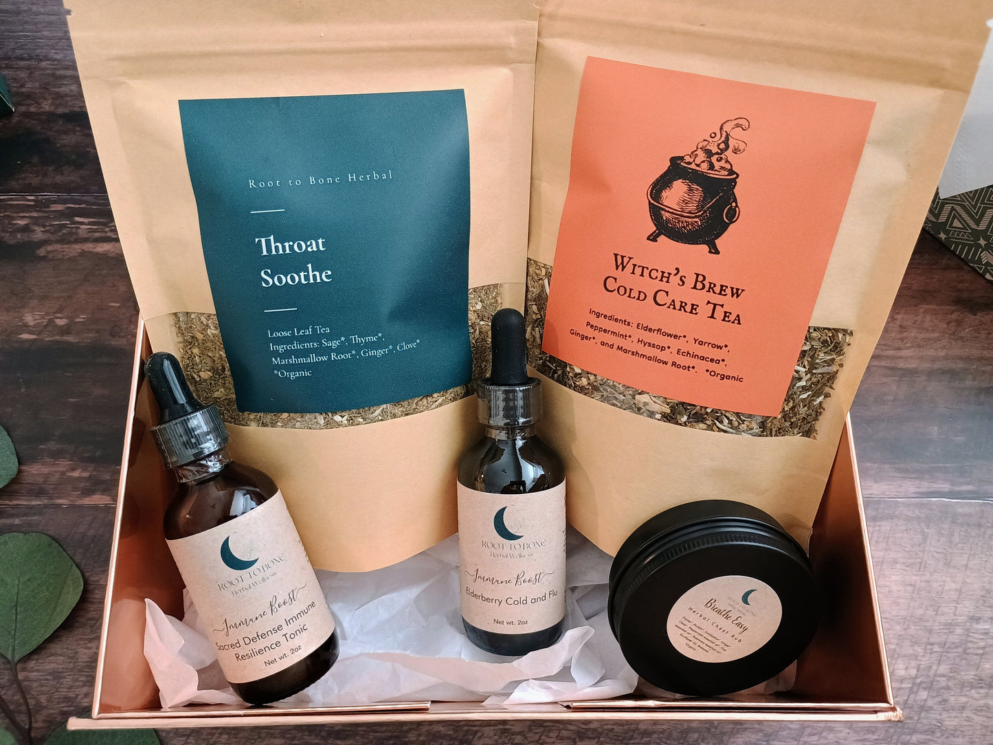 Herbal tea and wellness product set in a box on a wooden surface