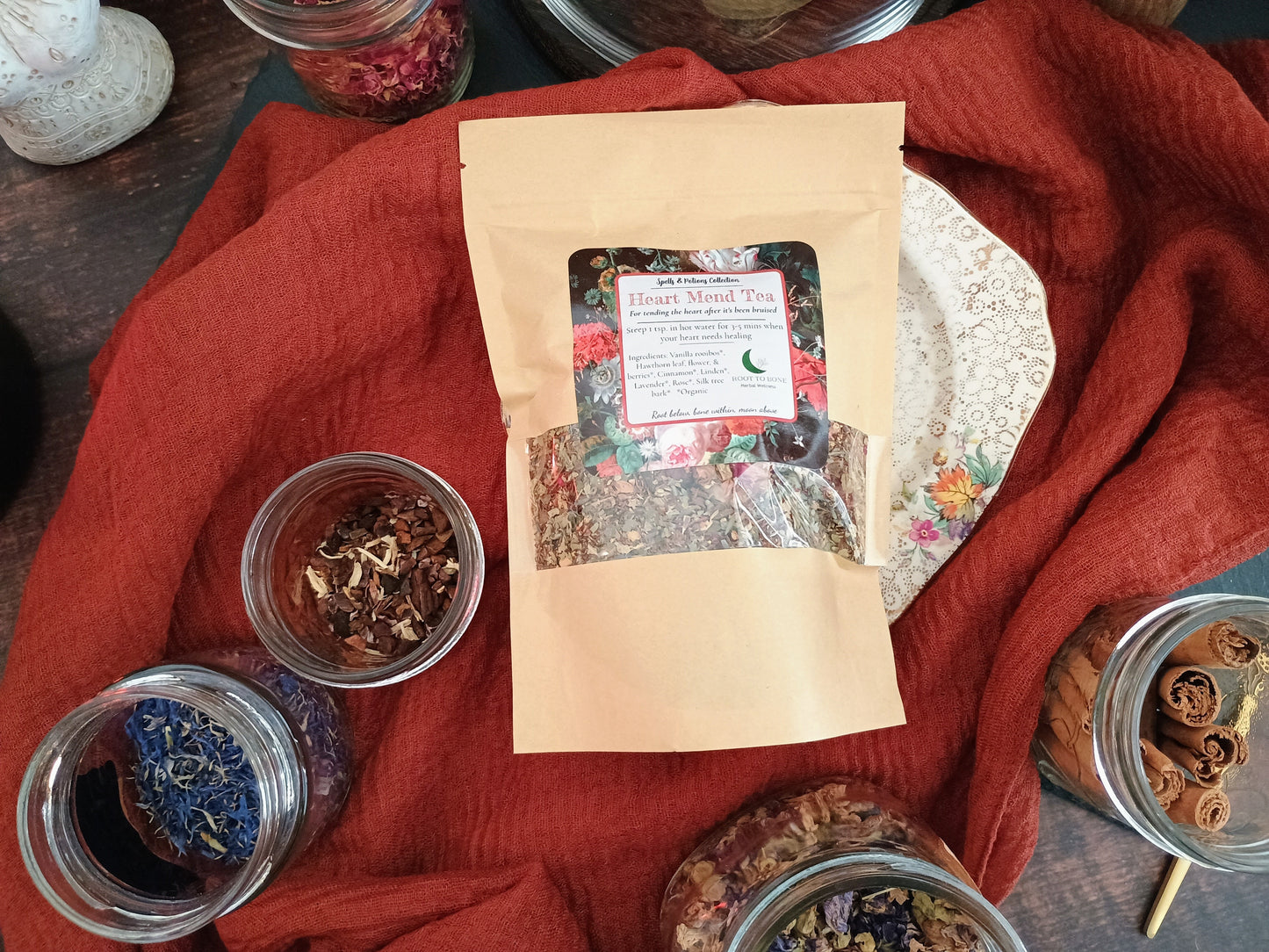 Tea packaging with dried herbs on a red fabric background