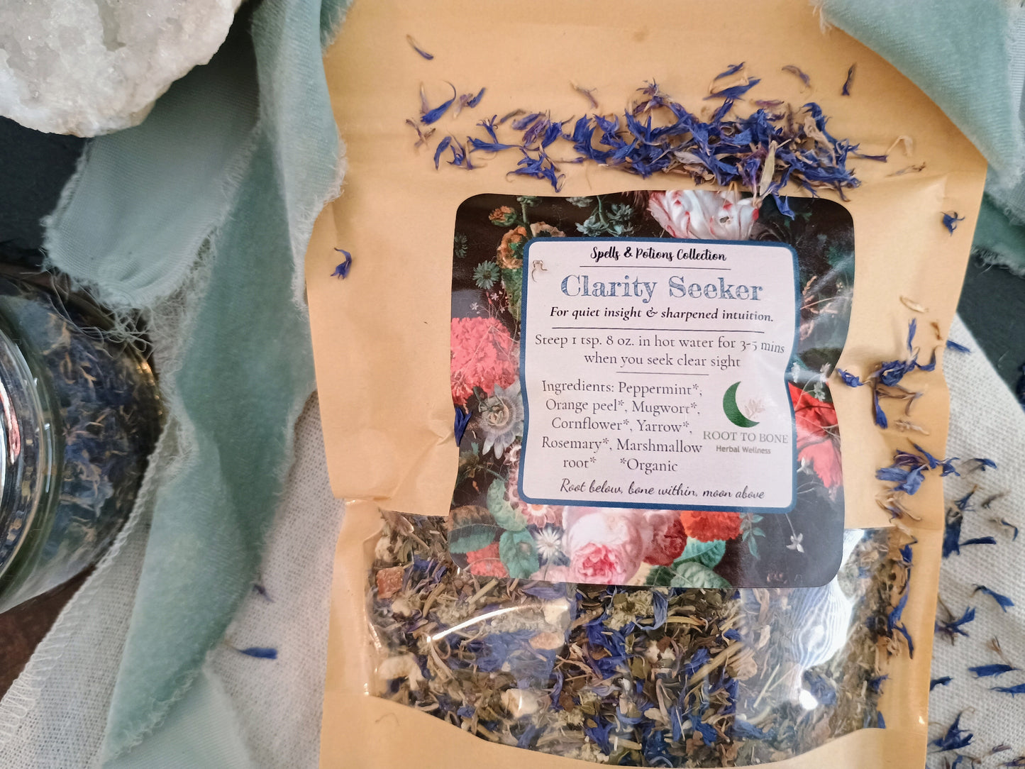 Tea package labeled 'Clarity Seeker' with dried herbs on a textured fabric background