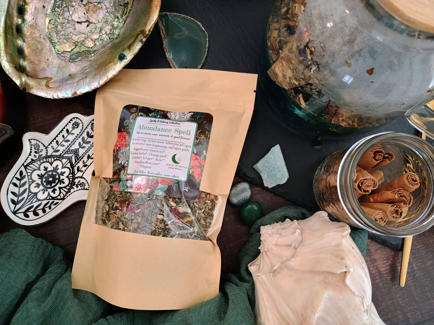 Herbal tea package on a table with various items including a jar of cinnamon sticks.