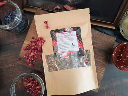 Love spell tea package on a wooden surface with dried flowers.
