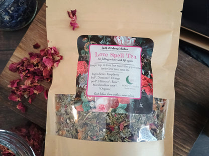 Bag of Love Spell Tea with a colorful label on a wooden surface with dried flowers.