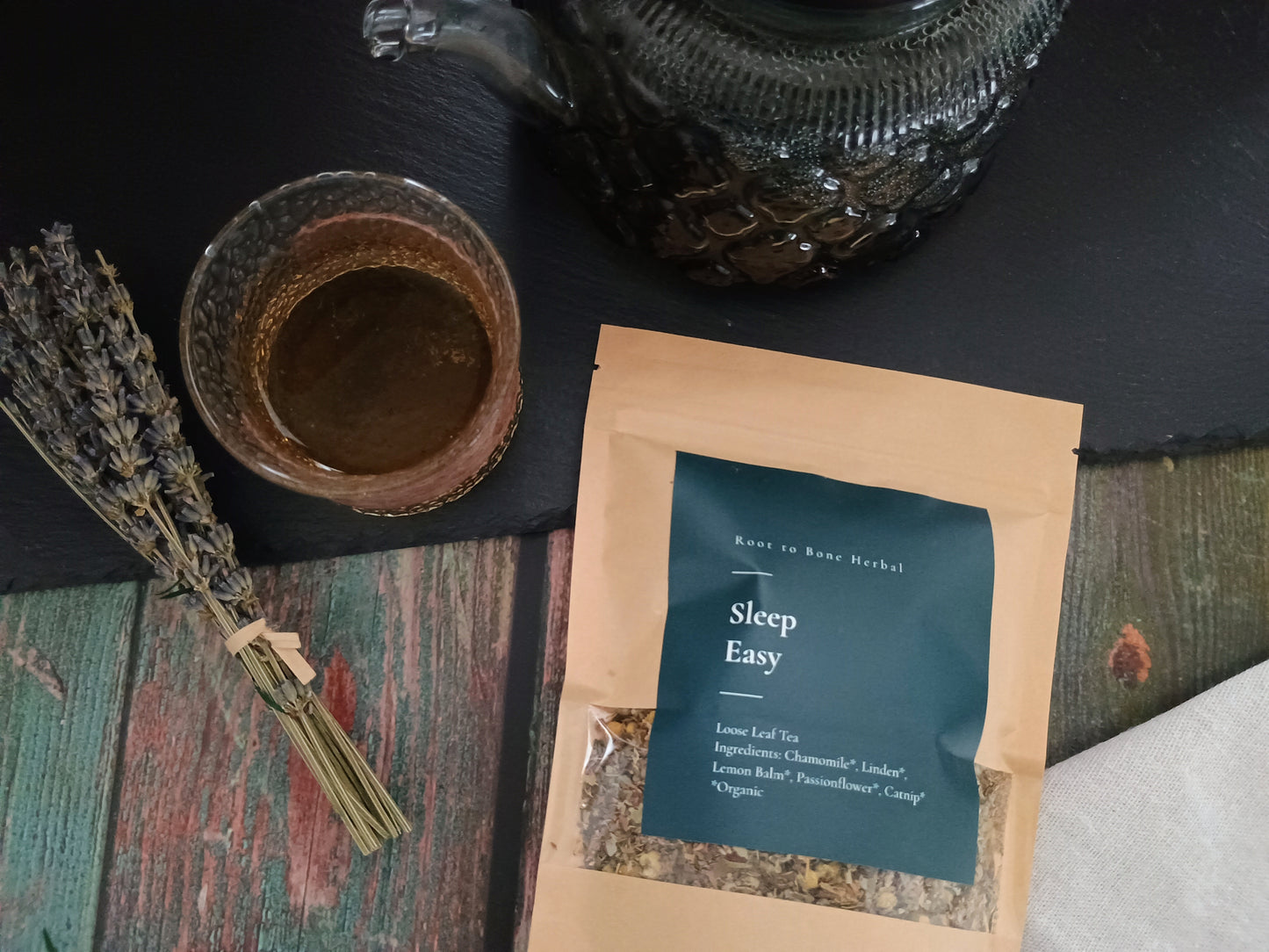 Tea package labeled 'Sleep Easy' with a cup of tea and lavender on a dark surface