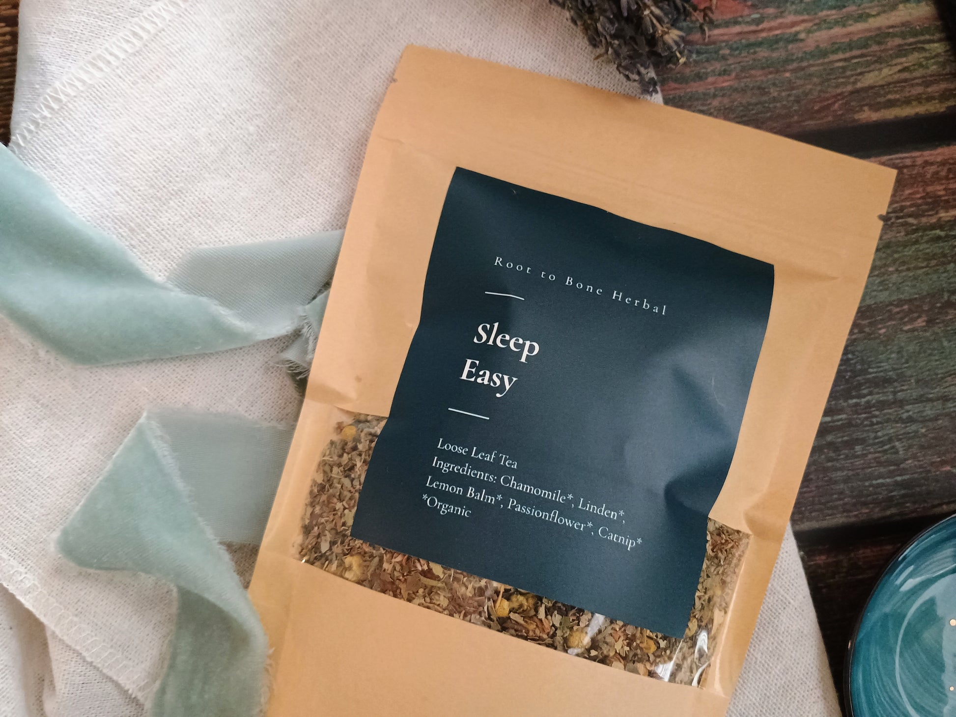 Tea package labeled 'Sleep Easy' with herbs visible on a textured surface