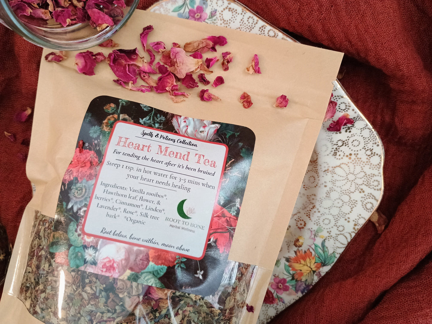Heart Mend Tea package with dried flowers on a floral tablecloth