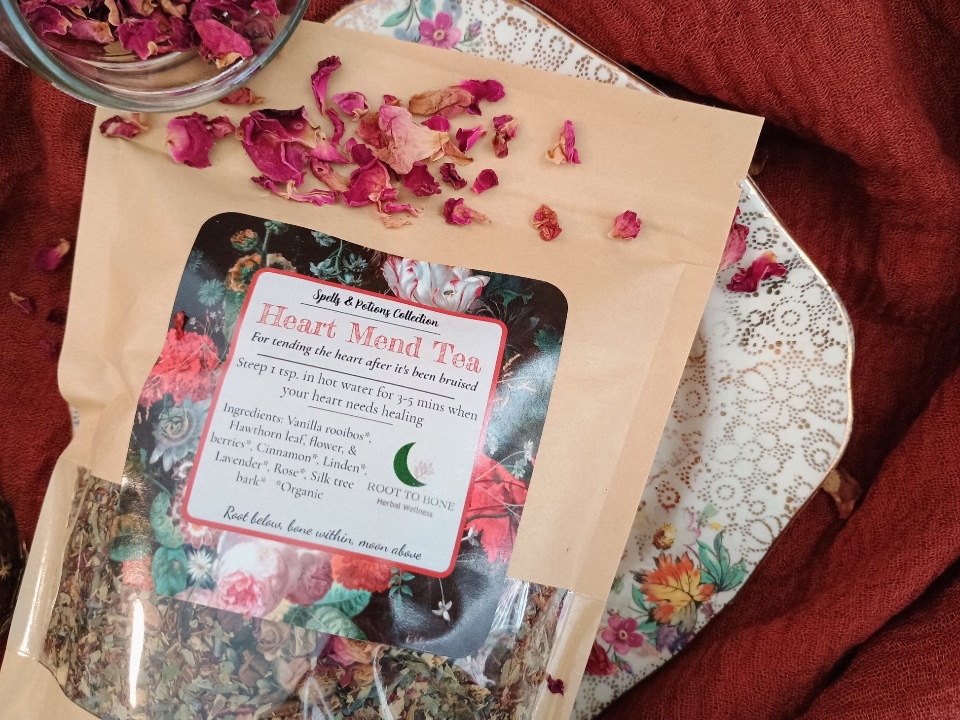 Heart Mend Tea package with dried flowers on a floral tablecloth