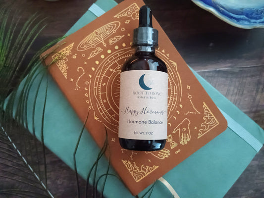 Bottle of 'Happy Hormones' on a decorative notebook with a wooden surface