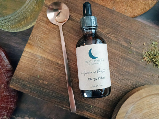 Bottle of 'Allergy Relief' on a wooden surface with a spoon and other items.