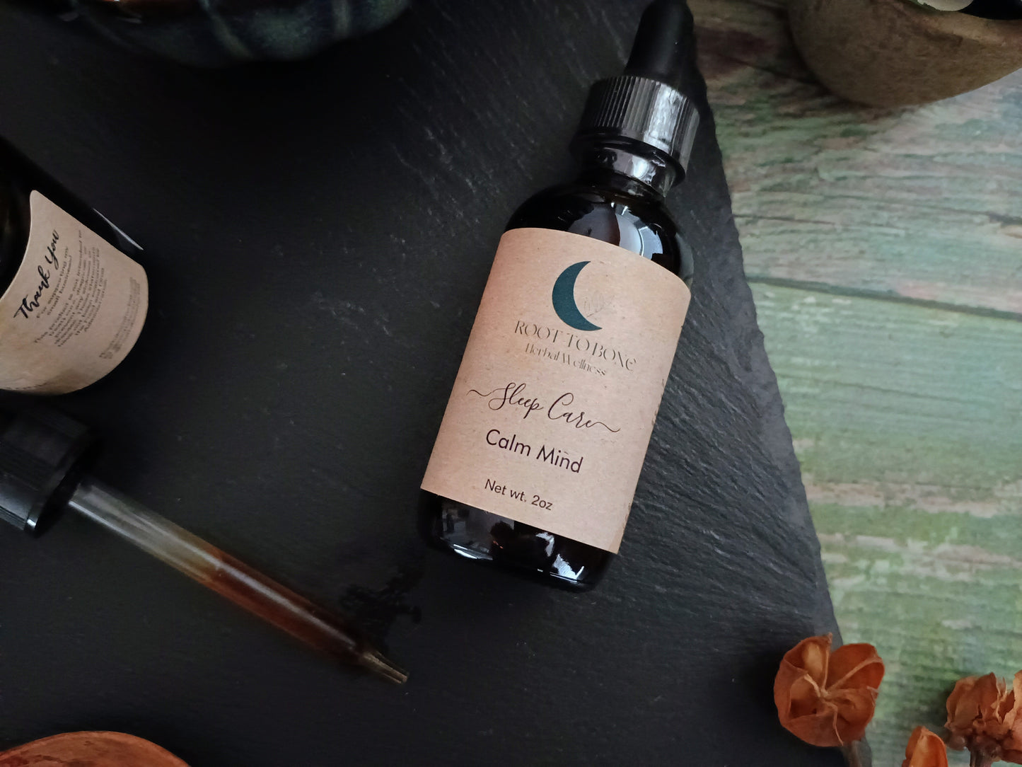Bottle labeled 'Sleep Care Calm Mind' on a dark surface with decorative elements.
