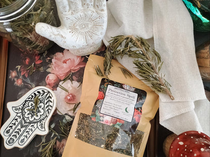 Herbal tea packaging with dried herbs, a handprint design, and a floral notebook.