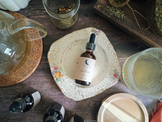 Bottle of tincture on a decorative plate with a wooden surface and jars in the background